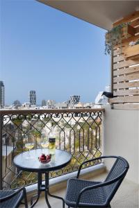 un tavolo e sedie su un balcone con vista di Elegant Apartment w Balcony & Mamad in Heart of Tel Aviv by Sea N' Rent a Tel Aviv