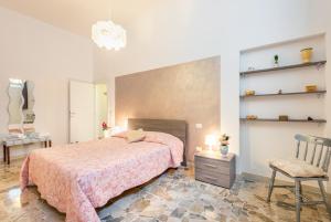 een slaapkamer met een bed, een stoel en planken bij Casa Vacanze Nonna Norma in San Miniato