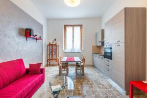 een woonkamer met een rode bank en een tafel bij Casa Vacanze Nonna Norma in San Miniato
