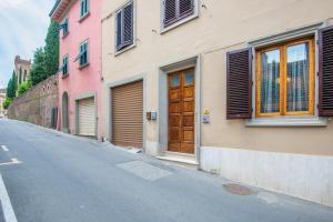 een lege straat met gebouwen en een houten deur bij Casa Vacanze Nonna Norma in San Miniato