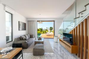 a living room with a couch and a television at Villa Laurus 6, walking distance to the beach in Paphos City