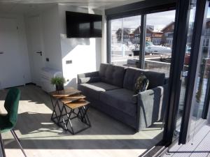 a living room with a couch and a table at Modern houseboat with air conditioning located in marina in Uitgeest