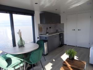 a kitchen with a table and chairs and a kitchen with a window at Modern houseboat with air conditioning located in marina in Uitgeest