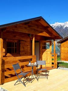 two chairs and a table in front of a cabin at SočaLand Glamping in Bovec
