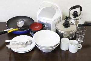 a table with plates and cups and a coffee maker at FLEXSTAY INN Shinagawa in Tokyo