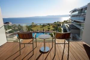 a balcony with a table and two chairs and the ocean at ON'LIVE HOTEL in Çeşme