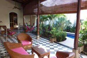 a patio with chairs and a hammock in a house at Hotel Casa Cubana Granada Nicaragua in Granada