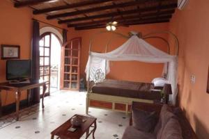 a bedroom with a canopy bed and a couch at Hotel Casa Cubana Granada Nicaragua in Granada