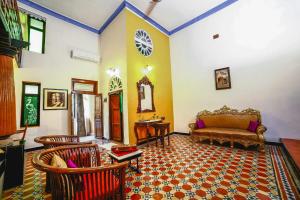 a living room with a couch and chairs at Indeco Hotels Swamimalai in Kumbakonam