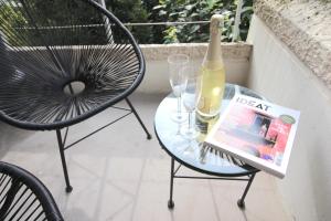 a glass table with a bottle of wine and two chairs at The Lake Aurora Suite - Duke Housing in Créteil