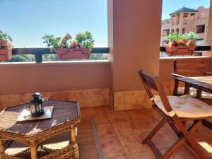 d'un balcon avec une table, des chaises et une table. dans l'établissement Apartamento Playa Verde, à Isla Canela
