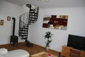 una sala de estar con una escalera de caracol en la pared en Bioweingut Schmidl Rosenstöckel, en Dürnstein