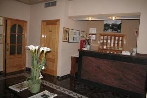 a lobby with a vase of flowers on a table at Hotel Guadalquivir in Cazorla +31 photos