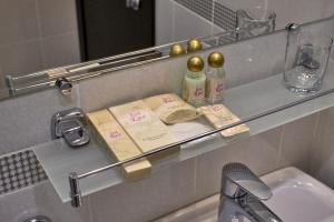 a bathroom with a glass shelf above a sink at Pioneer Luxe Hotel in Saratov +37 photos
