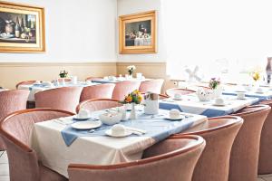 a row of tables in a room with chairs at Löwen Hotel in Offenbach