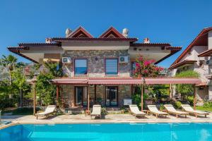 a house with a swimming pool in front of a house at Vira Apart Suites in Göcek