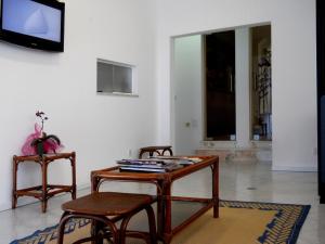 a living room with a table and two chairs and a tv at Hotel Sra da Conceicao in Praia de Mira