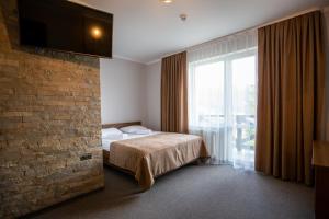 a hotel room with a bed and a large window at Князів Двір in Bukovel