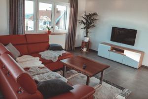 a living room with a red couch and a table at Ferienwohnung inmitten der Natur mit Sauna in Steinau an der Straße