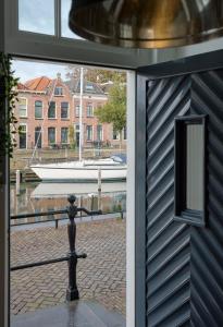 una puerta con vistas a un barco en el agua en B&B De Grote Kade I Bella Zeelandia en Goes