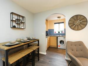 a kitchen with a table and a clock on the wall at Rothwell Close Serviced Two Bed Apartment in Telford