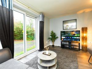 a living room with a tv and a large window at Rothwell Close Serviced Two Bed Apartment in Telford