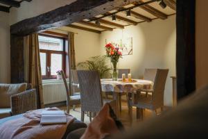 a dining room with a table and chairs with flowers on it at De Mandenvlechter in Dilsen-Stokkem