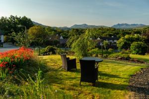 a table and chairs in a yard with mountains in the background at The Walk-up in Portree
