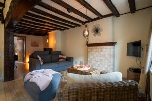 a living room with a couch and a fireplace at De Mandenvlechter in Dilsen-Stokkem