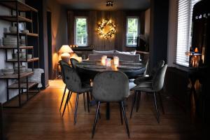 a dining room with a black table and chairs at Au bois colin in Durbuy