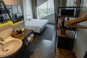 a hotel room with a bed and a sink and a window at Janevalla Bandung in Bandung