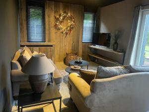 a living room with two couches and a television at Au bois colin in Durbuy