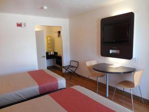a hotel room with a bed and a tv on the wall at Motel 6-Chula Vista, CA - San Diego in Chula Vista