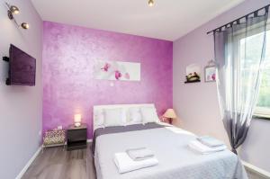 a bedroom with purple walls and a large bed at Apartment Tenega in Dubrovnik