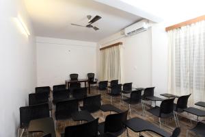 a room with black chairs and tables and a window at Hotel Crimson Lotus in Bangalore