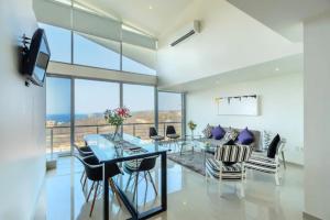 a living room with a glass table and chairs at LOFT PANORAMICO DE LUJO 631 - PUNTA GAVIOTA in Tangolunda