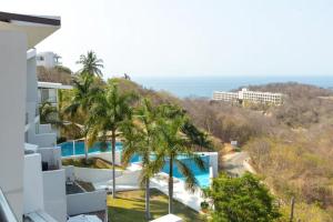 arial view of a building with a pool and palm trees at LOFT PANORAMICO DE LUJO 631 - PUNTA GAVIOTA in Tangolunda