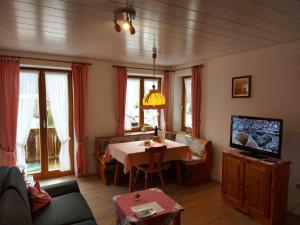 uma sala de estar com uma mesa e uma televisão em Gästehaus Annabell em Nesselwang