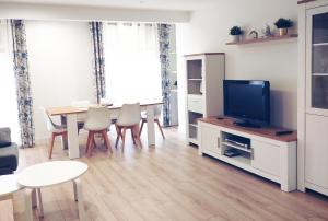 uma sala de estar com uma televisão e uma mesa e cadeiras em Apto Ramón y Cajal,1- Céntrico y cerca de Playa San Lorenzo-3hab garaje opc em Gijón