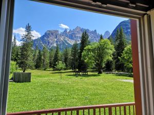 a view from a window of a field with mountains at Delizioso monolocale in Dobbiaco