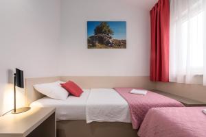 een slaapkamer met 2 bedden, een raam en een bureau bij Apartments Grota in Poreč +62 foto's