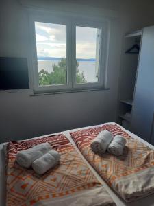 ein Schlafzimmer mit einem Bett mit zwei Kissen und einem Fenster in der Unterkunft Novi Lux in Novi Vinodolski