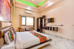 Habitación de hotel con cama y TV en FabHotel Prime Sumanglam, en Dehradun
