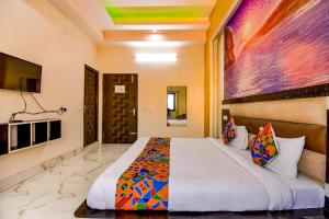 1 dormitorio con 1 cama grande en una habitación en FabHotel Prime Sumanglam, en Dehradun