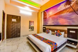 1 dormitorio con 1 cama y una gran pintura en la pared en FabHotel Prime Sumanglam, en Dehradun