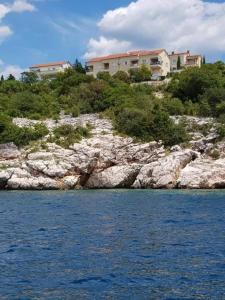 ein Haus auf einem felsigen Hügel neben dem Wasser in der Unterkunft Novi Lux in Novi Vinodolski