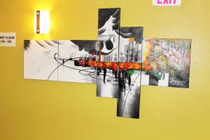 a cross painting hanging on a wall at Super 8 by Wyndham South Boston VA in South Boston