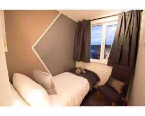 a bedroom with a bed and a window and a chair at Ideal Lodgings in Baxenden in Accrington