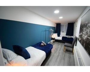 1 dormitorio con 2 camas y pared azul en Ideal Lodgings in Baxenden, en Accrington