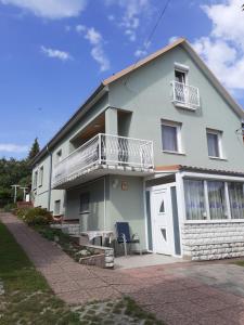 Dieses weiße Haus verfügt über einen Balkon und eine Terrasse. in der Unterkunft XXL Apartman in Zalakaros